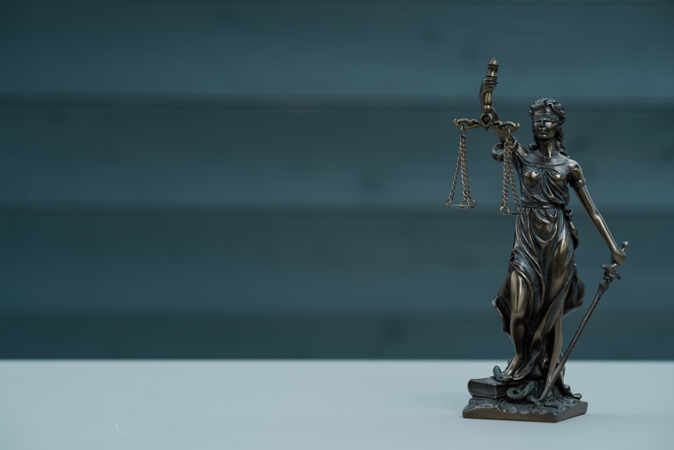 Law and Justice concept. Mallet of the judge, books, scales of justice. Gray stone background, reflections on the floor, place for typography. Courtroom theme.